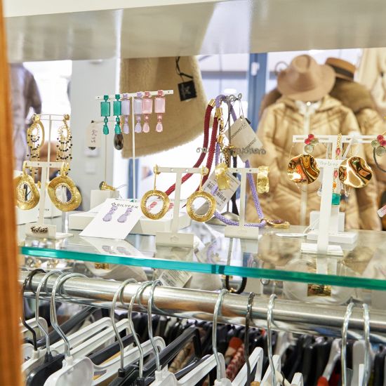 Vitrina con pendientes, pulseras y collares dorados expuestos en una boutique.